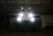 Czołg Ripsaw 2 w garażu z włączonymi światłami